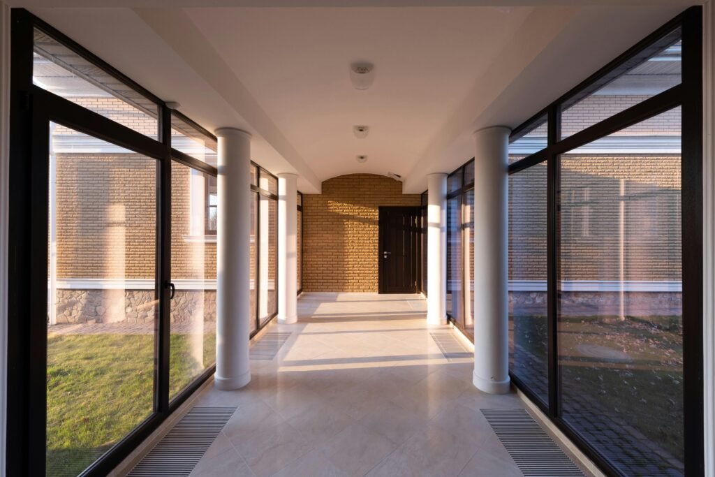 Spacious modern corridor with large glass windows and bright natural light.